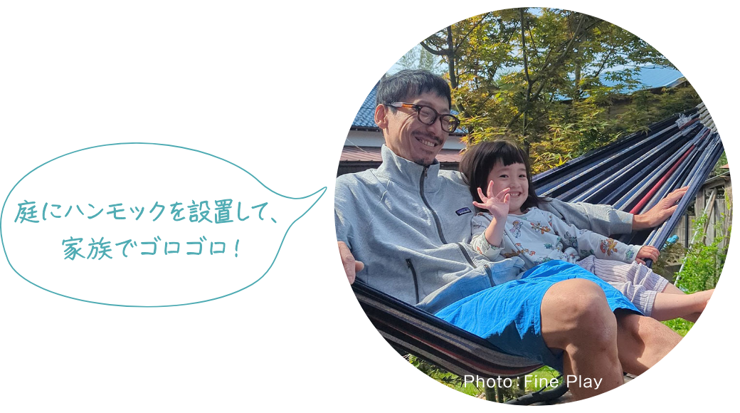庭に吊るしたハンモックでくつろぐ親子