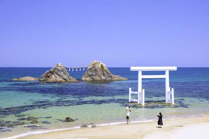 糸島市北部に位置する県の名勝「二見ヶ浦」。海岸から約150ｍの沖合にしめ縄で結ばれ、夫婦のように寄り添って並ぶのは「夫婦岩」と呼ばれるご神体の巨岩。櫻井神社の社領になっており、代々黒田藩主の崇敬を受けてきたことから桜井二見ヶ浦とも呼ばれている